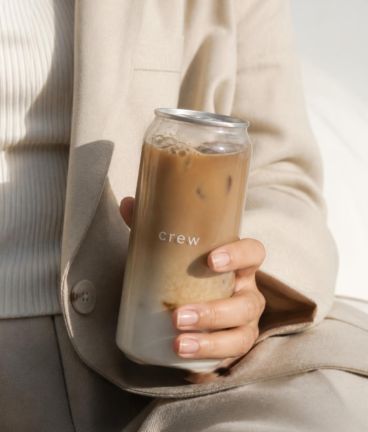 hand holding a crew iced latte can